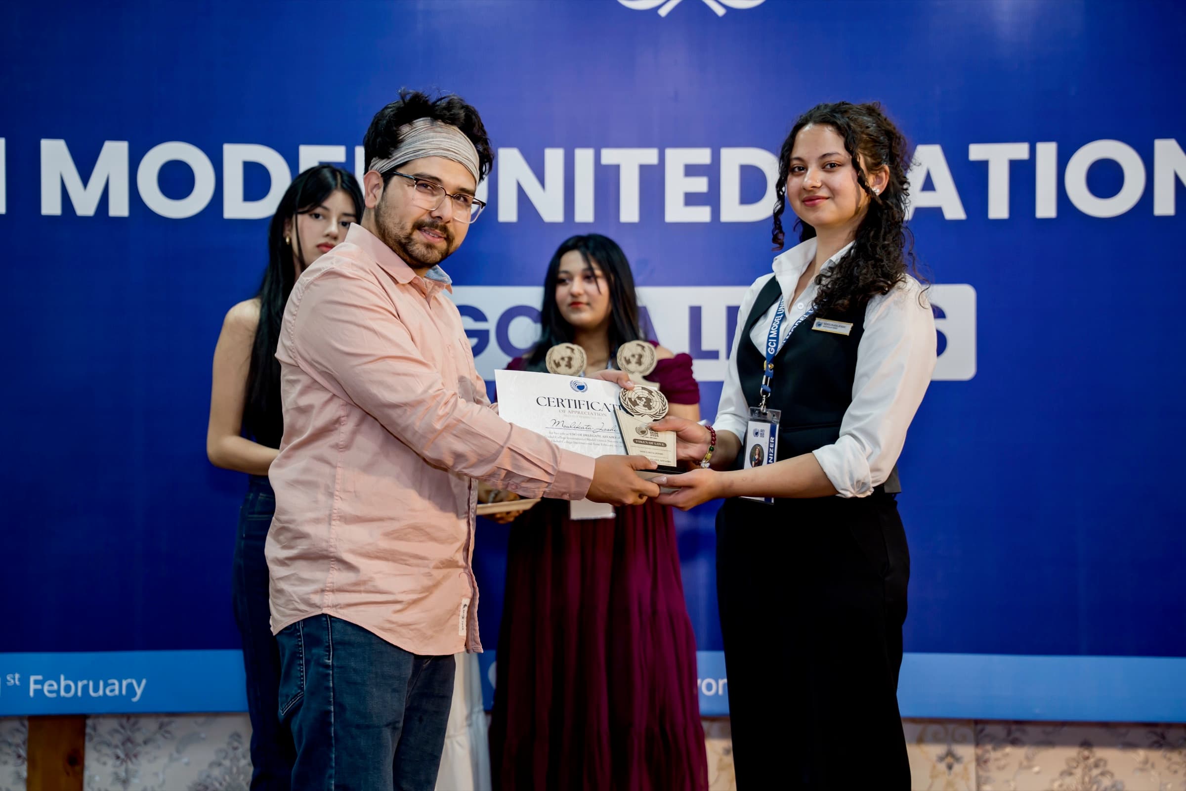 Moulikta receiving a GCIMUN award on stage