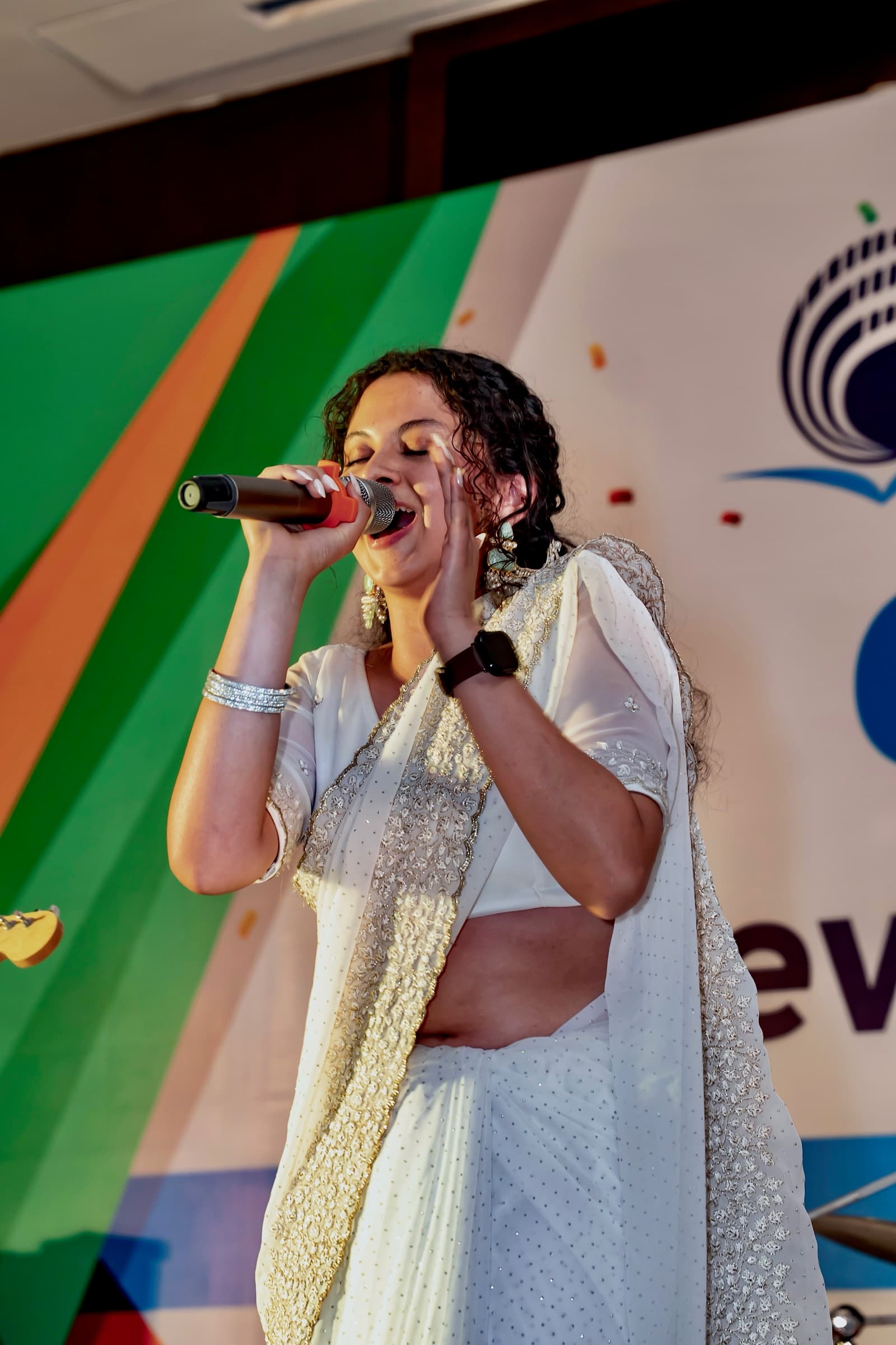 Moulikta singing in a white sari at her college farewell