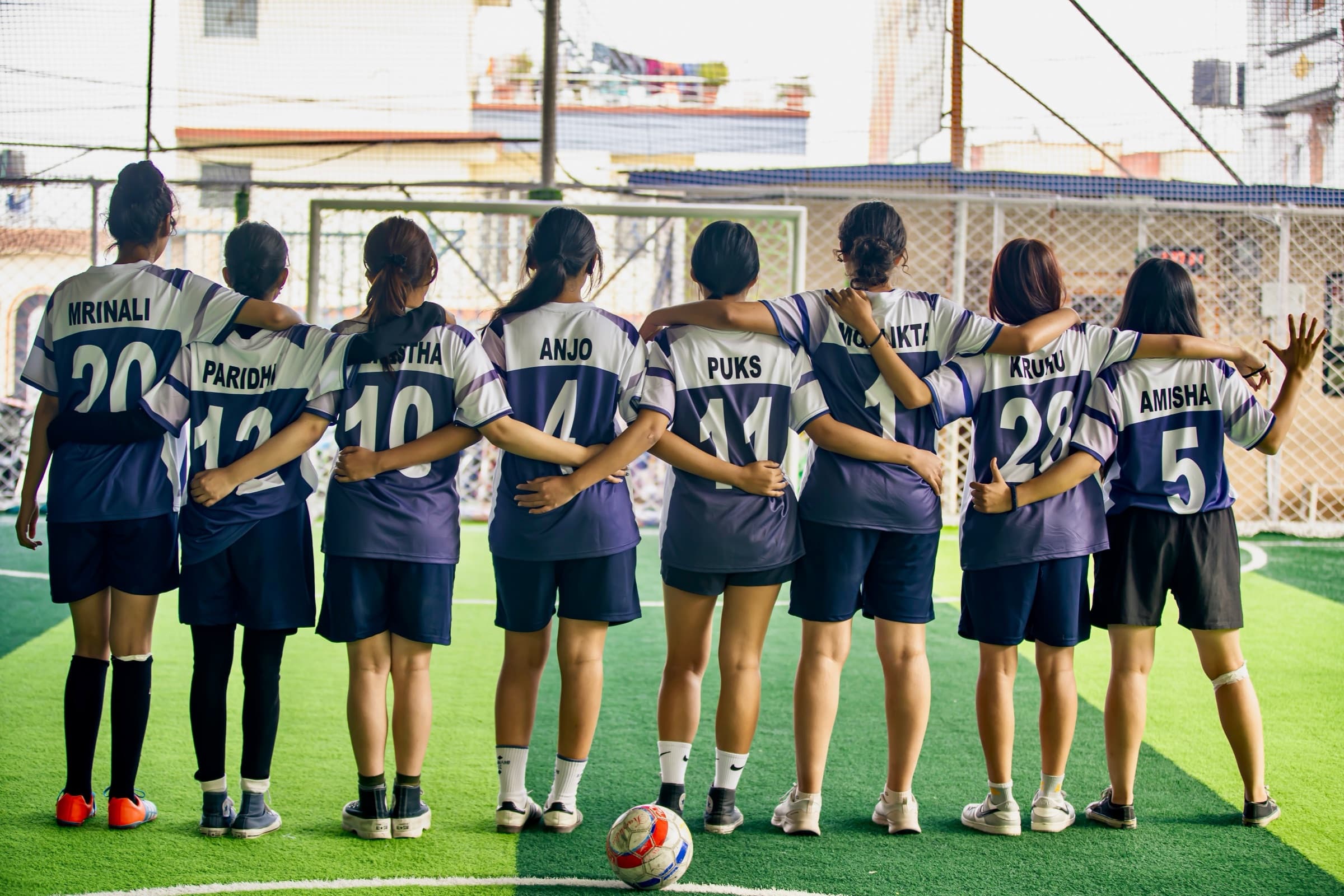GCI girls football team standing together in their numbered jerseys